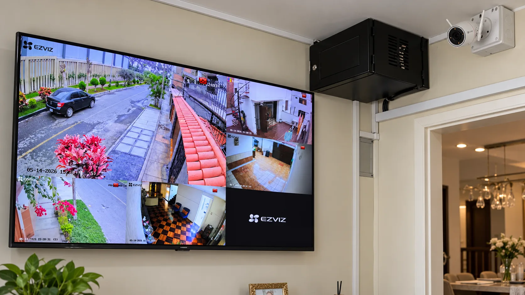 Sistema CCTV residencial con monitor de múltiples cámaras, gabinete y cámara instalada